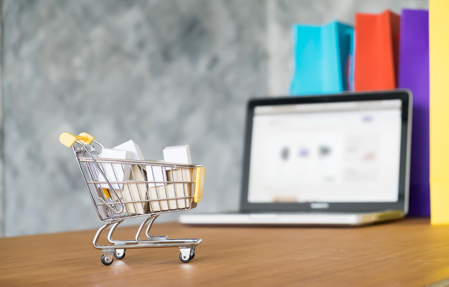 E-commerce shopping cart on laptop with product bags representing online retail analytics